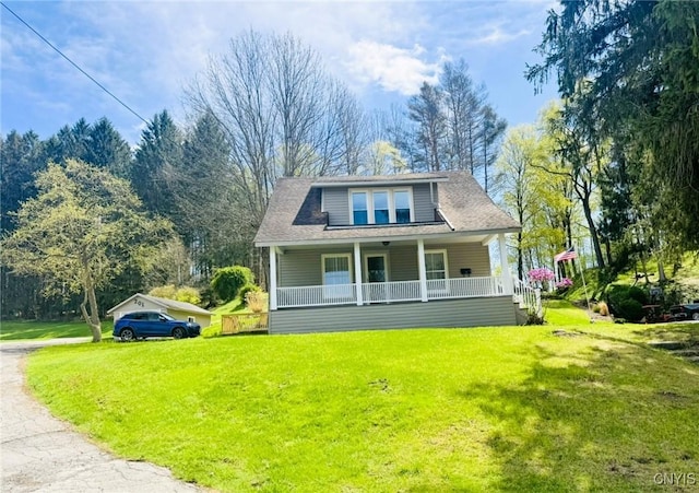 bungalow featuring covered porch and a front lawn