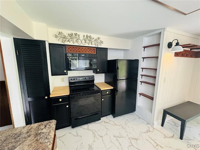 kitchen with dark cabinetry, black appliances, and marble finish floor
