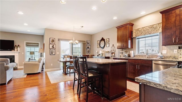kitchen featuring an inviting chandelier, dishwasher, hardwood / wood-style floors, open floor plan, and a kitchen island