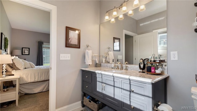 bathroom with plenty of natural light, vanity, ensuite bathroom, and baseboards