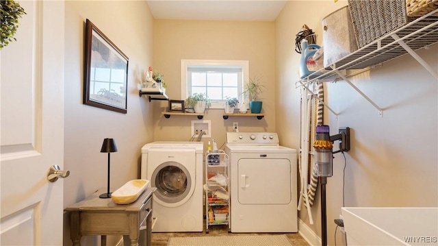 clothes washing area featuring laundry area, a sink, and washing machine and dryer
