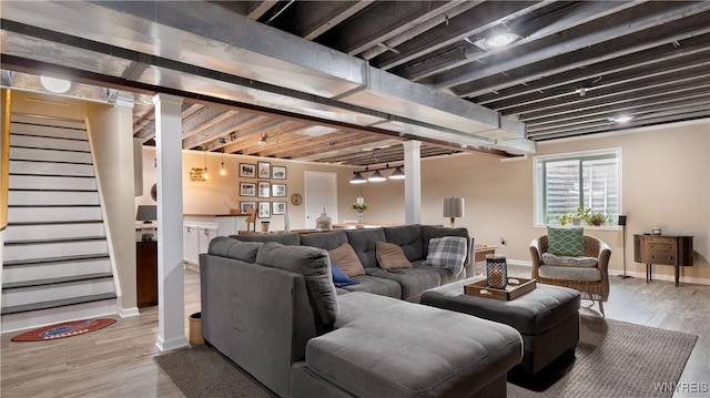 living room featuring stairway, baseboards, and wood finished floors