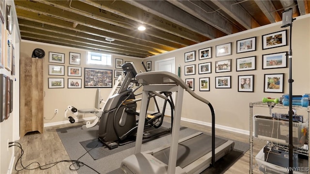 exercise room featuring baseboards and wood finished floors