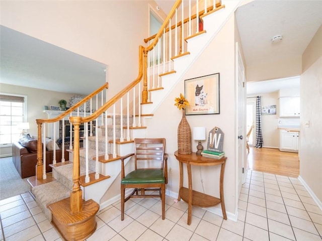 staircase with baseboards and tile patterned flooring