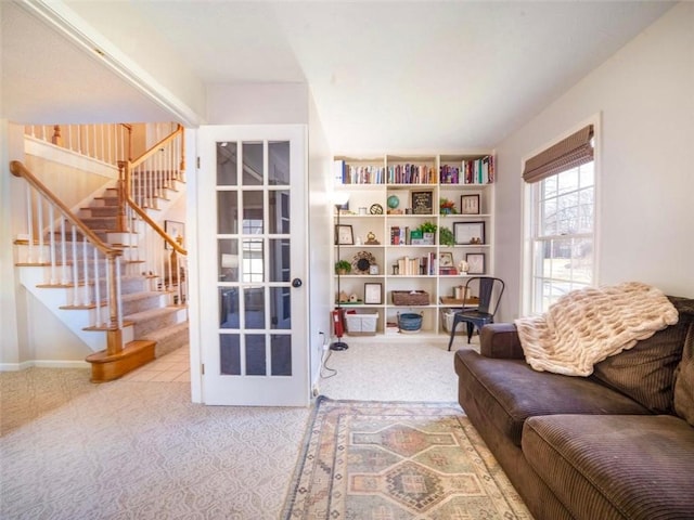 living area featuring stairs and carpet