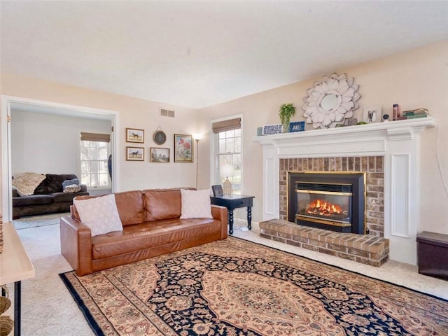 carpeted living room with visible vents and a fireplace