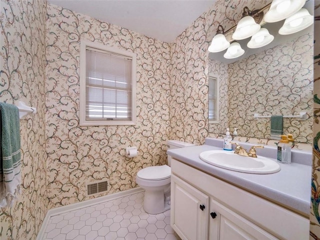 bathroom featuring wallpapered walls, visible vents, baseboards, and tile patterned flooring
