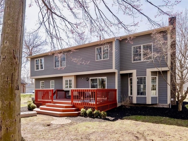 rear view of house with a chimney and a wooden deck