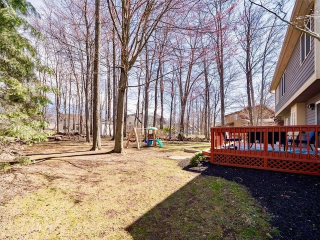 view of yard featuring a playground and a deck