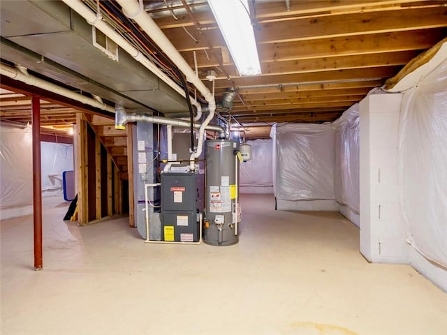 unfinished below grade area featuring heating unit and water heater