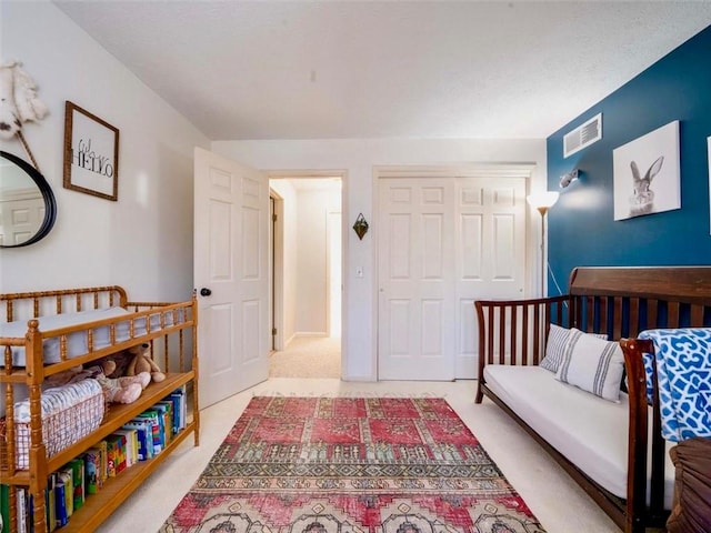 bedroom featuring visible vents, a closet, and light colored carpet
