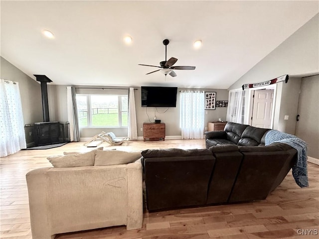 28053 Boat Launch Rd, Lyme, NY 13622 - living area featuring ceiling fan, a wood stove, baseboards, light wood-type flooring, and vaulted ceiling