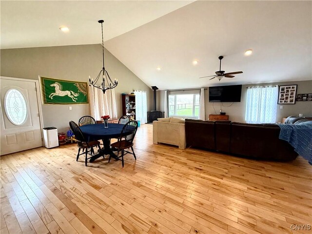 28053 Boat Launch Rd, Lyme, NY 13622 - dining space with high vaulted ceiling, ceiling fan with notable chandelier, and light wood-style flooring
