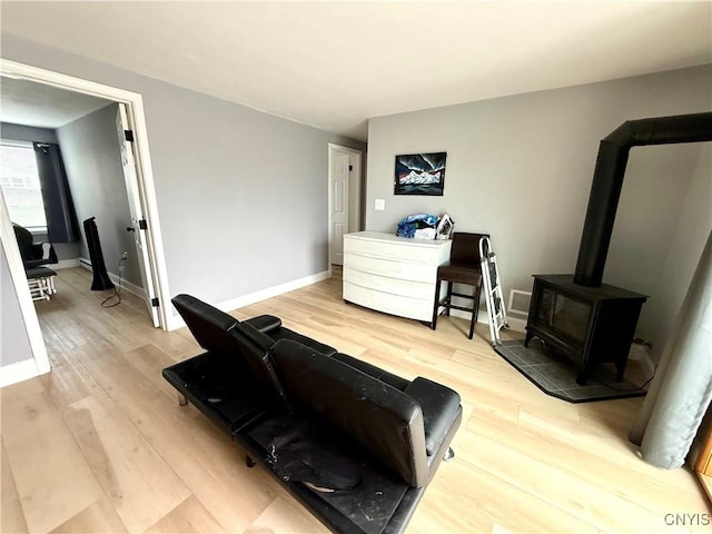 28053 Boat Launch Rd, Lyme, NY 13622 - interior space featuring baseboards, a wood stove, and light wood-type flooring