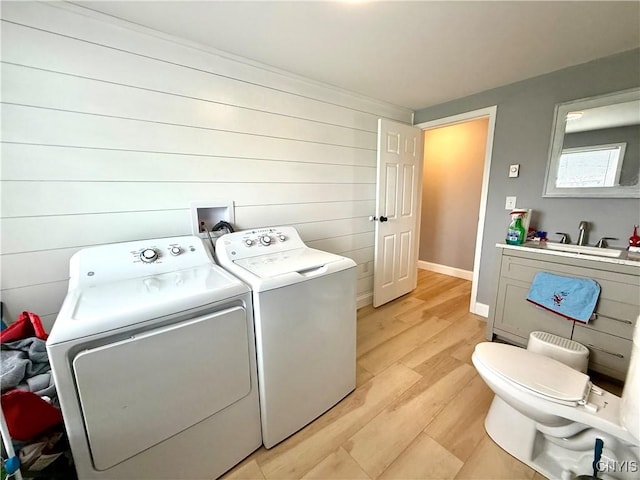 28053 Boat Launch Rd, Lyme, NY 13622 - washroom with laundry area, baseboards, a sink, light wood finished floors, and independent washer and dryer