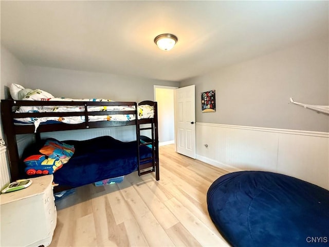 28053 Boat Launch Rd, Lyme, NY 13622 - bedroom featuring wood finished floors and a wainscoted wall