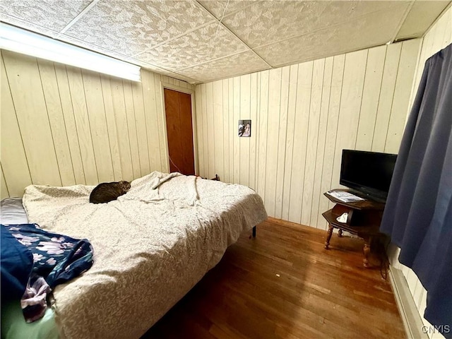 bedroom featuring wood walls and wood finished floors