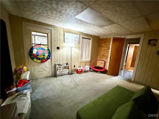 recreation room featuring carpet flooring and wooden walls