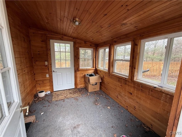 unfurnished sunroom with wooden walls and vaulted ceiling