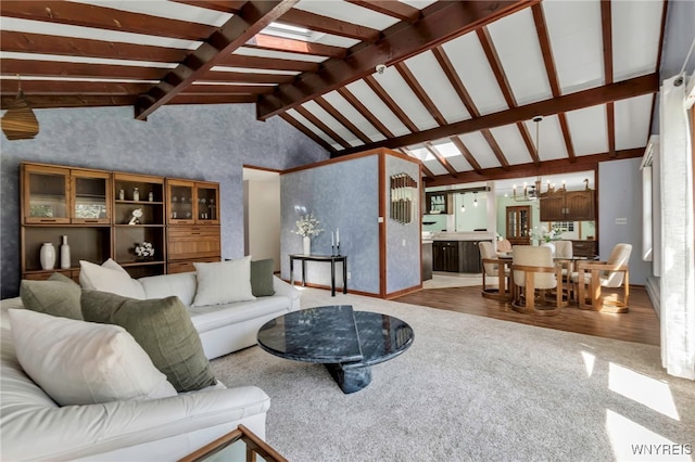 carpeted living area with baseboards, lofted ceiling with beams, and wood finished floors