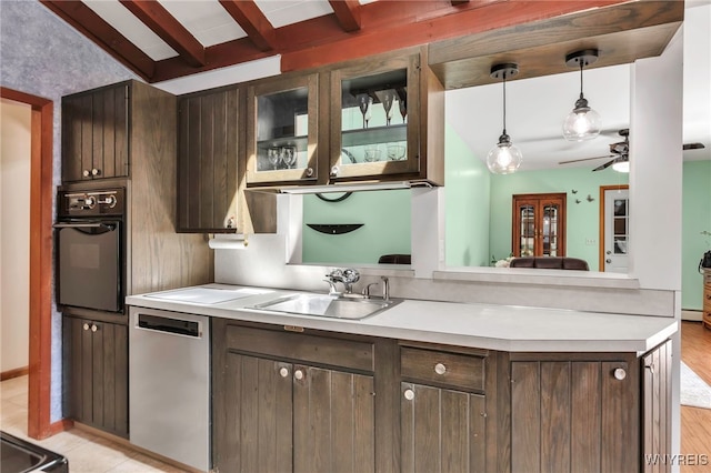kitchen with stainless steel dishwasher, a sink, black oven, and dark brown cabinets