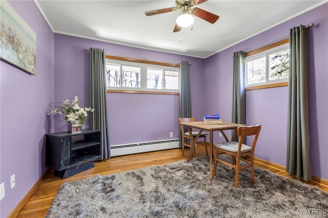 office area with plenty of natural light, crown molding, ceiling fan, and a baseboard heating unit