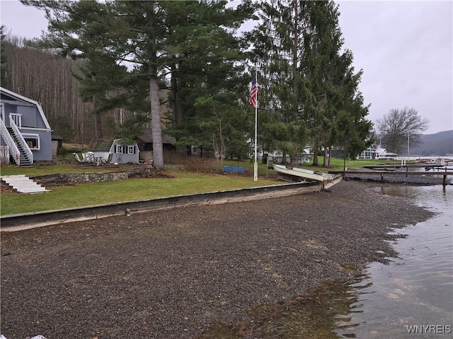 exterior space with stairs, a water view, and curbs