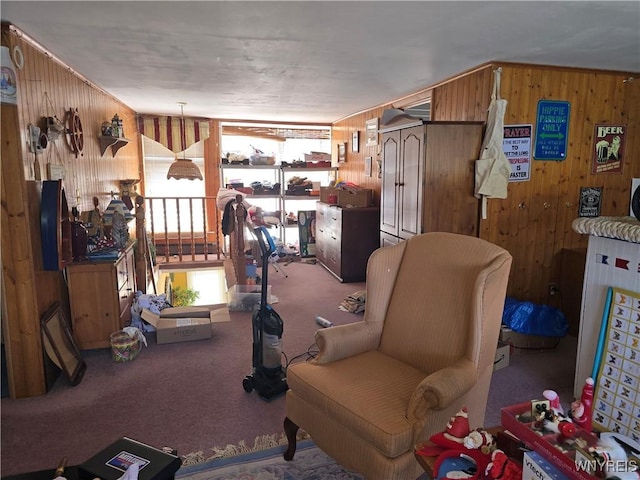 sitting room with carpet floors and wood walls