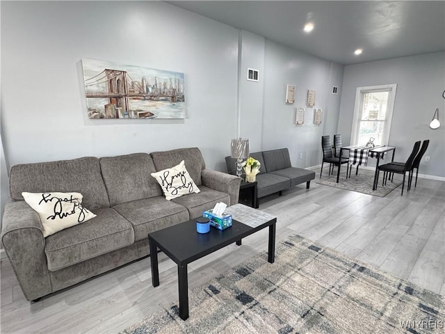 living room with recessed lighting, baseboards, visible vents, and light wood-type flooring