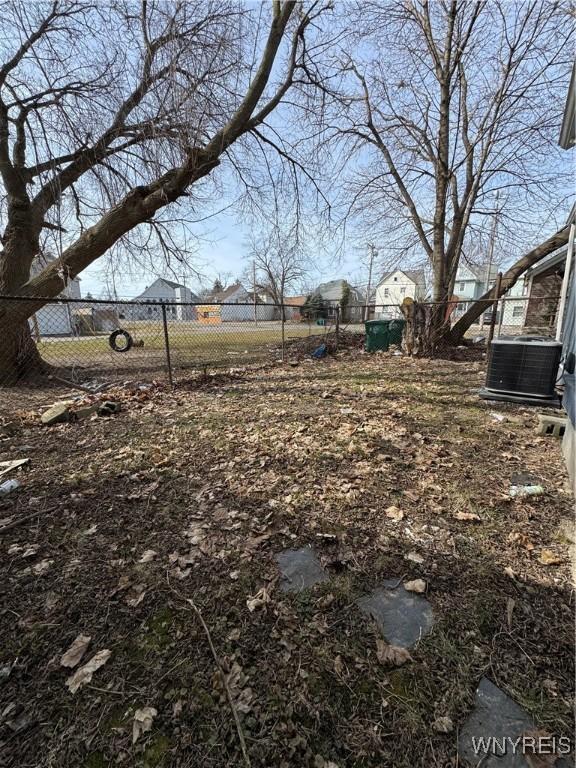 view of yard with central air condition unit and fence