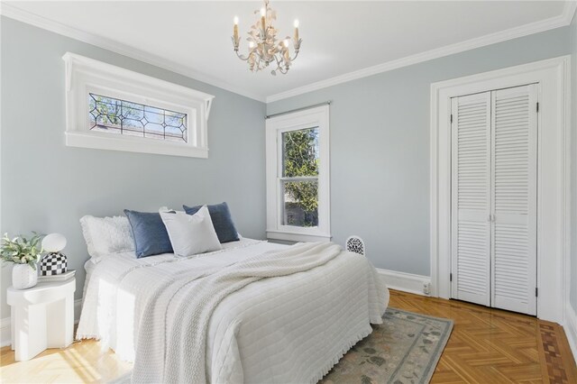 bedroom with crown molding, baseboards, a chandelier, and a closet