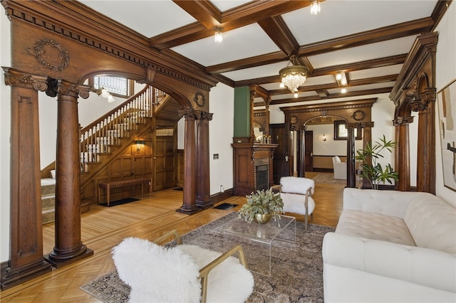 living room with arched walkways, stairs, baseboards, ornate columns, and beamed ceiling