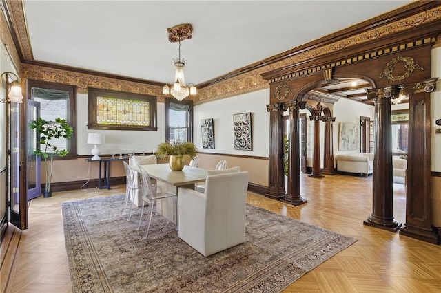 dining room featuring arched walkways, baseboards, ornamental molding, and decorative columns