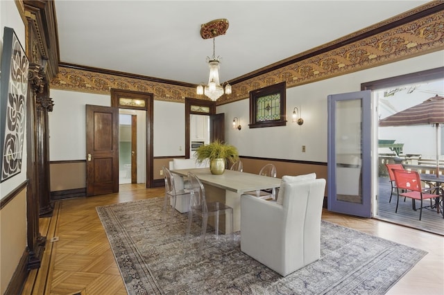 dining area featuring an inviting chandelier, baseboards, and crown molding