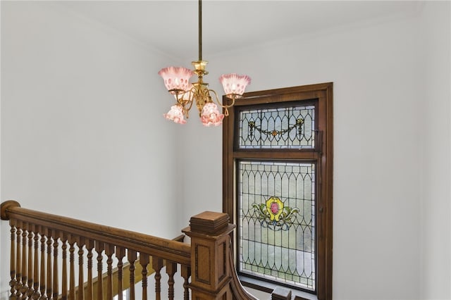 foyer featuring an inviting chandelier and crown molding