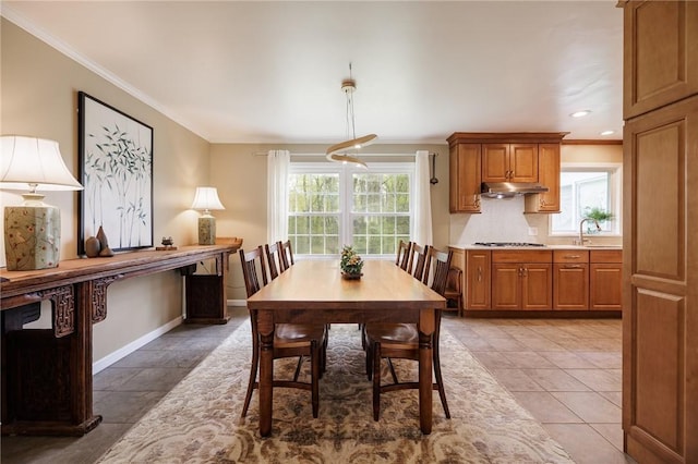 dining space with baseboards, ornamental molding, a healthy amount of sunlight, and recessed lighting