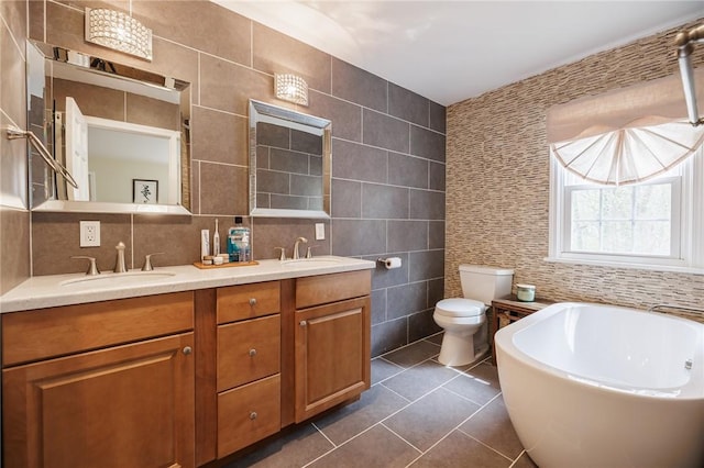 bathroom featuring tile walls, a sink, tile patterned flooring, and a garden tub