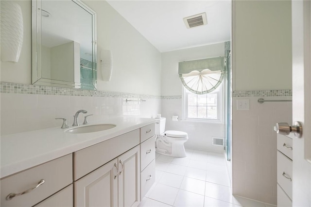 full bathroom featuring visible vents, tile patterned flooring, toilet, and tile walls