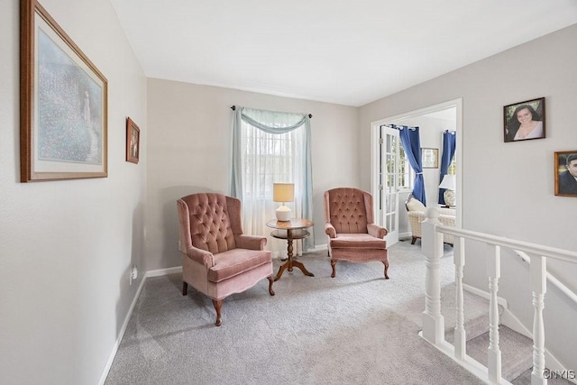 living area featuring carpet flooring and baseboards