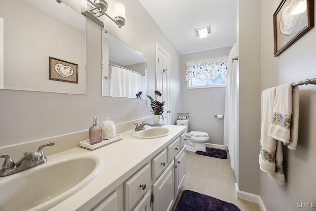 bathroom featuring visible vents, a sink, double vanity, and toilet