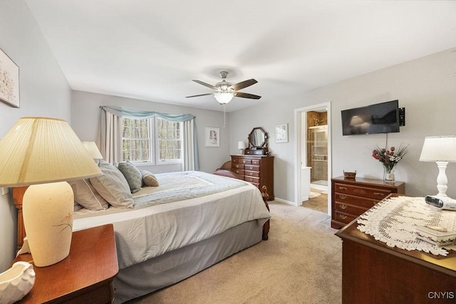 bedroom featuring baseboards, ensuite bathroom, a ceiling fan, and light colored carpet