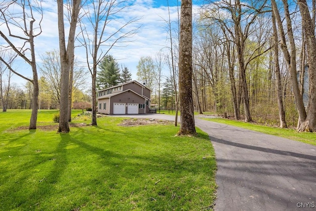 view of front of house featuring a garage, driveway, and a front lawn