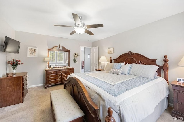 bedroom with light colored carpet, baseboards, and ceiling fan