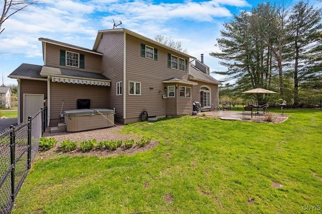 back of property featuring a hot tub, a patio area, a yard, and fence