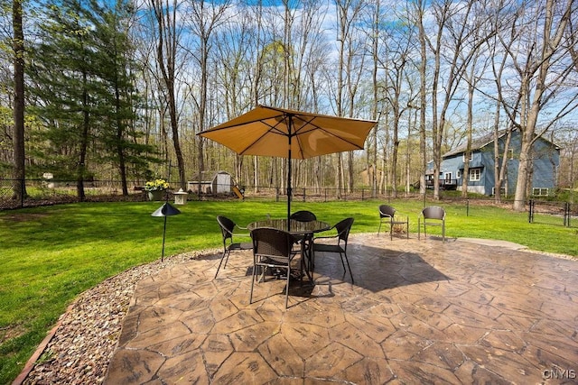 view of patio featuring an outdoor structure, a storage shed, and a fenced backyard