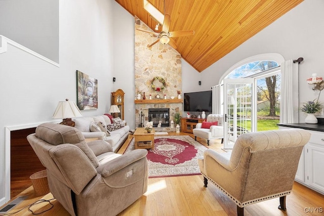 living area with a fireplace, ceiling fan, high vaulted ceiling, wooden ceiling, and light wood finished floors