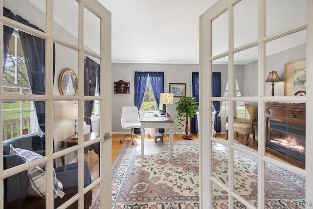 office with plenty of natural light, french doors, and wood finished floors