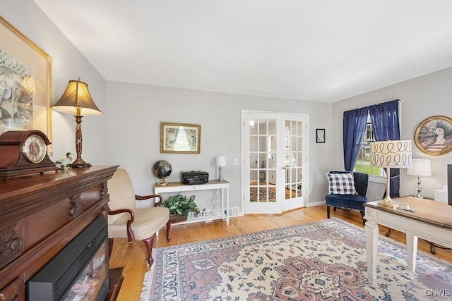 living area with baseboards, french doors, and wood finished floors