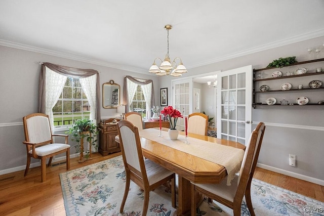 dining space with crown molding, baseboards, light wood-type flooring, and a chandelier