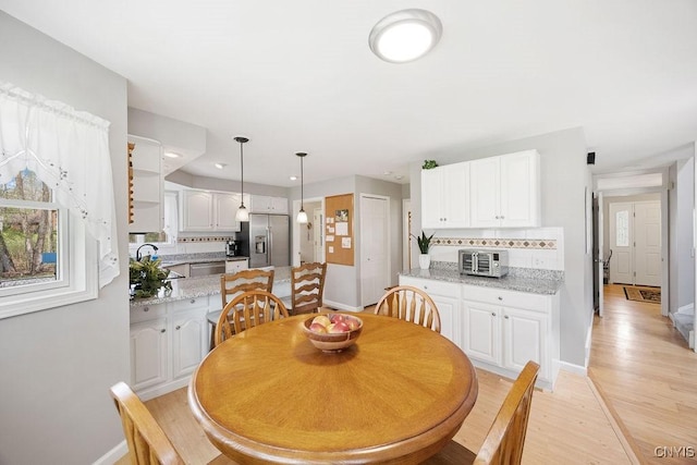 dining space with recessed lighting, baseboards, light wood-style flooring, and a toaster